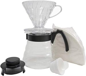 Conjunto para fazer café, da marca Hário. Contendo: uma jarra de vidro, com pegador de plastico preto, um porta filtro Hario V60 transparente, uma colher medidora, um pacote de filtros de papel.